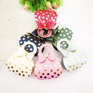 Assorted colorful wedding favor boxes with gold polka dots and elegant ribbon handles