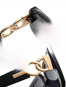 Macro detail of the durable golden metal chain hinge on square black sunglasses