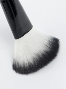 Macro detail of dual-tone black and white gradient bristles on a fan makeup brush head