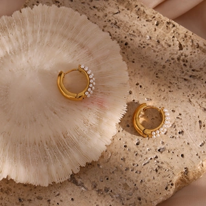 Macro detail of 18K gold-plated hoop earrings with pearls on sea urchin shell