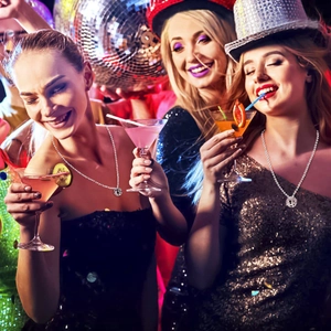 Close-up of women wearing silver disco ball necklaces at a festive party with cocktails