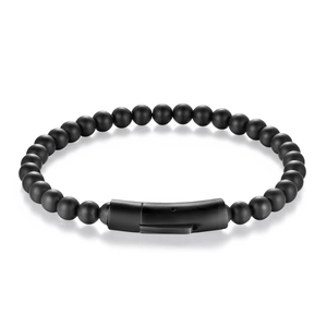 Macro view of matte black onyx beads and brushed metal magnetic clasp on men's bracelet