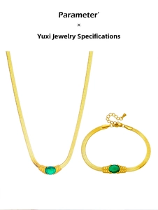 Detail of vintage gold snake chain set with emerald green oval gemstones and adjustable clasp