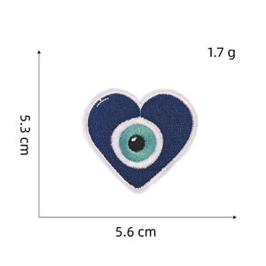 Macro view of blue heart-shaped Evil Eye embroidery patch showing 5.6cm width detail