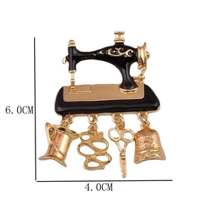Detail view of a vintage sewing machine brooch with charms and 6.0cm x 4.0cm size marks