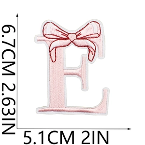 Pink embroidered letter E patch with bow detail and 6.7cm x 5.1cm size measurement
