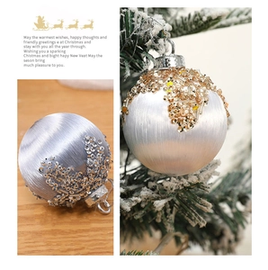 Detail of glittered purple and white foam Christmas balls hanging on a pine tree