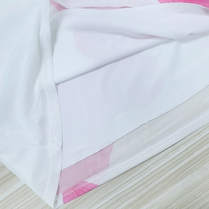 Detailed macro view of pink floral print mesh fabric with double-stitched hem finish