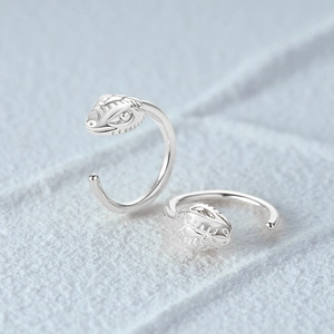 Macro shot of S925 sterling silver snake shape ear hook earrings on gray surface