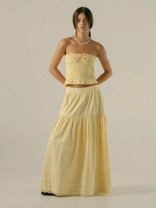 Detail of smocked bandeau top and tiered A-line skirt set in soft pastel yellow fabric
