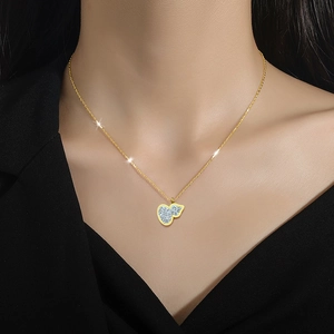 Minimalist gold titanium steel necklace with a sparkling heart pendant worn by a model