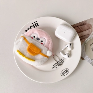 Close-up of pink plush penguin earphone case with beads chain on a white plate