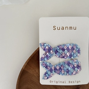 Detail of glitter sequin mermaid tail hair clips in purple and blue on card