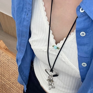 Long collier cordon noir avec pendentif abstrait argenté sur un mannequin en bleu