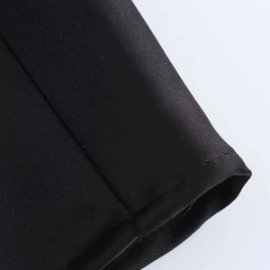 Detailaufnahme von schwarzem Satinstoff mit feiner Köperstruktur und präzisen Nähten