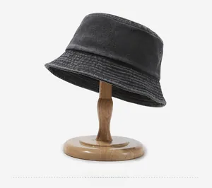 Close-up of charcoal grey washed denim bucket hat with reinforced brim and metal eyelets