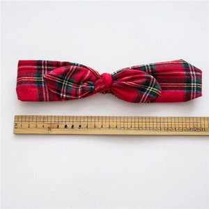 Red and green plaid Christmas knotted headband with rabbit ears on a white background