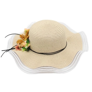 Détail d'un chapeau de paille à large bord avec fleurs jaunes et bordure en dentelle blanche