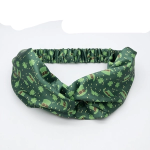 Green St. Patrick's Day knotted headband with shamrock and hat patterns on fabric