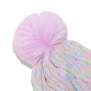 Macro view of colorful gradient knit winter hat with fluffy pink faux fur pom-pom detail