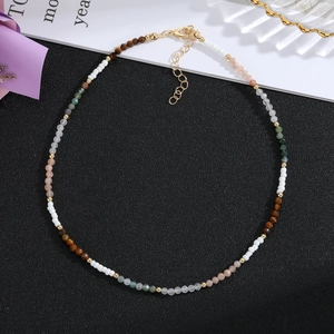 Detail of colorful handmade stone beaded necklace with gold spacers and lobster clasp