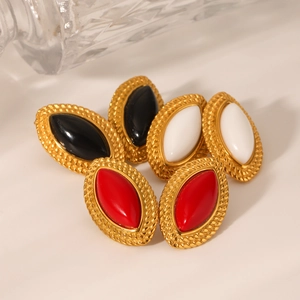 Close-up of vintage marquise earrings in red black and white with gold braided edges
