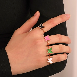 Detailed view of colorful butterfly rings in black pink green and white enamel
