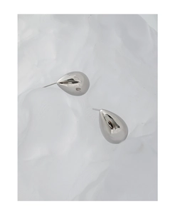 Macro shot of minimalist silver-tone teardrop earrings with a polished mirror finish