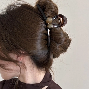 Détail de la pince à cheveux boule ambrée avec motif marbré en résine de qualité