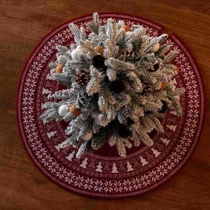 Red knitted Christmas tree skirt with white snowflake patterns on a dark wooden background