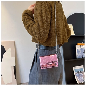 Close-up of pink faux crocodile leather mini crossbody bag with silver chain strap