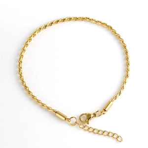 Détail d'un bracelet gourmette torsadé en acier inoxydable doré avec fermoir mousqueton