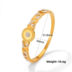 Detail of gold hollow bangle with crystal pavé center and Greek key pattern edges