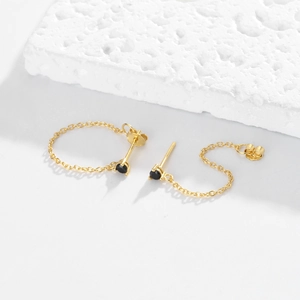 Detailed macro of gold S925 sterling silver chain earrings with black round zircon stones