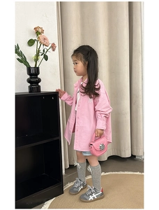 Detail of pink long-sleeved shirt with NY embroidery and matching pink handbag