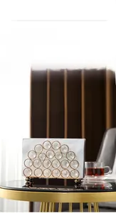 Close-up of golden metal napkin holder with crystal ball detail on a mirror table