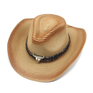 Détail d'un chapeau de cowboy en paille avec bande ethnique et pendentif tête de taureau