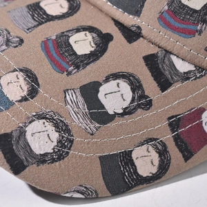 Detailed close-up of cartoon girl pattern and stitching on a brown cotton baseball cap