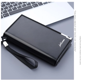 Detail of black leather long wallet for men with wrist strap in a business setting