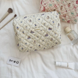Détail de trousses de maquillage matelassées avec motif lapin et texture coton doux