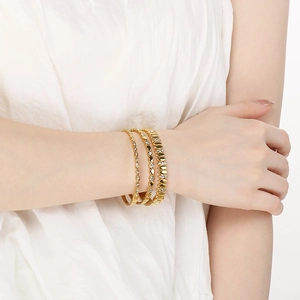 Three-piece 18K gold plated oval bangle set with white zircon stones on model wrist
