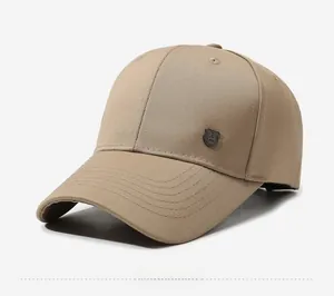 Side view detail of a tan baseball cap with a textured fabric and metal shield badge