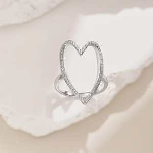 Macro shot of silver S925 heart hollow ring with sparkling cubic zirconia on stone base