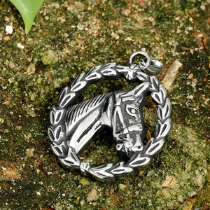 Vintage stainless steel horse head pendant necklace with laurel wreath on mossy ground