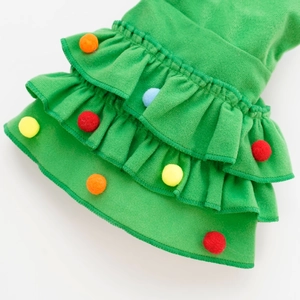 Detailed view of green Christmas pet cloak with layered ruffles and colorful pom poms