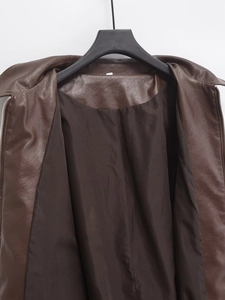 Detail of dark brown faux leather bomber jacket showing inner lining and metallic zipper