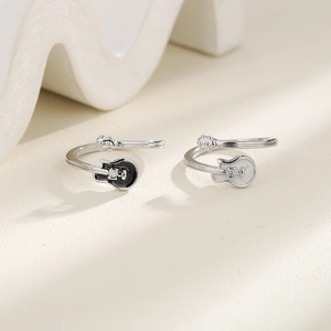 Detailed view of adjustable black and white electric guitar rings with small diamonds