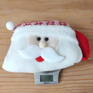 Detail showing plush Santa Claus Christmas stocking weight measurement on a kitchen scale