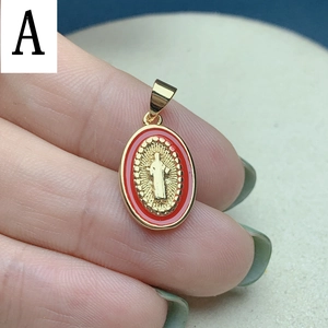 Macro detail of oval gold Jesus pendant with red enamel border and embossed central figure