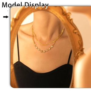 Detail of double-layer gold snake chain necklace with heart zircon in a vintage mirror view